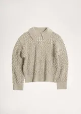Jersey de punto calado con textura gruesa, cuello polo y terminaciones de canalé en puños y ruedo.
