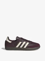 Championes Adidas Samba OG de caña baja, con diseño clásico de puntera en forma de T y tres bandas laterales dentadas. Presenta un empeine de cuero con estampado texturizado en color bordó y detalles en crema, sobre una suela de goma oscura.