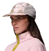 Gorro tipo gorra Columbia modelo Wingmark Cap, con paneles laterales de malla gris y diseño estampado camuflado en tonos rosados y blancos en el frente y la visera. Cuenta con logo bordado de la marca.