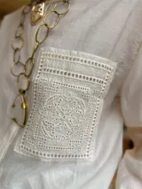 Camisa blanca de diseño liso con cuello mao y un bolsillo delantero decorado con detalles en broderie.