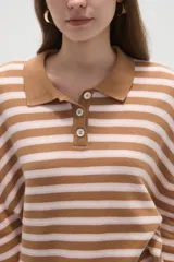 Remera de manga larga con diseño a rayas horizontales, cuello tipo polo con cierre de botones y corte holgado.
