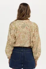 Blusa estampada con diseño paisley en tonos beige y amarillo, con mangas abullonadas de tres cuartos y escote en V profundo.