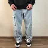 Pantalón jean cargo negro con corte holgado y múltiples bolsillos.