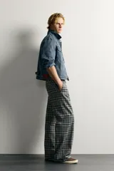 Pantalón flare fit confeccionado en tejido con algodón, con estampado a cuadros en tonos grises y negros. Cuenta con bolsillos laterales, bolsillos traseros de vivo y cierre frontal con cremallera y botón.