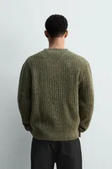 Jersey de punto con textura acanalada y efecto jaspeado, de corte regular, cuello redondo y manga larga con terminaciones en rib.