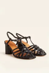 Sandalia de cuero negro con tiras cruzadas en el empeine, diseño en T con tira ajustable al tobillo y taco cuadrado.