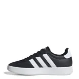 Championes urbanos Adidas modelo Urban Barreda T, con diseño inspirado en siluetas retro de los 80. Presentan una capellada que combina cuero sintético y gamuza en color negro, con las icónicas tres tiras laterales en blanco y suela de goma blanca.