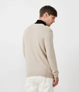 Suéter masculino de corte slim confeccionado en tejido de punto color beige. Presenta un diseño de rayas horizontales contrastantes en el pecho en tonos marrón y azul marino, cuello redondo, mangas largas y terminaciones en rib en puños y bajo.