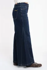 Jean de corte wide leg y tiro medio, confeccionado en denim de algodón. Presenta costuras verticales decorativas a lo largo de las piernas y cierre frontal con botón y cremallera.