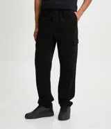 Pantalón cargo de hombre color negro, confeccionado en sarga de algodón, con cintura elástica, bolsillos laterales tipo cargo y bolsillos traseros.