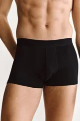 Pack de tres calzoncillos tipo trunk de color negro, confeccionados en punto elástico con costuras planas y cintura elástica. Presentan piernas cortas y parte delantera forrada para mayor comodidad.