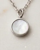Collar de plata con cadena de eslabones finos y diseño asimétrico que incluye tres pequeños discos metálicos y un dije circular principal con incrustación de nácar.