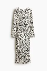 Vestido midi entallado de punto con estampado de leopardo, cuello redondo, manga larga y espalda descubierta con detalle cruzado en la cintura.