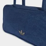 Bolso tipo airliner de Adidas confeccionado en tejido denim azul. Presenta un diseño alargado con manijas largas para llevar al hombro, cierre principal y logo del Trifolio metálico en la parte frontal.