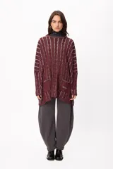 Sweater de tejido artesanal con diseño de rayas verticales en tonos camel y beige, corte holgado, cuello redondo y puños altos ajustados.