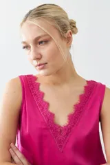 Top satinado color fucsia con escote en V y detalles de encaje en el borde del escote. Sin mangas y de corte holgado.