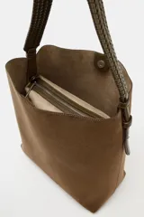 Bolso de hombro formato saca en color marrón, con asa superior trenzada y cierre mediante clip metálico. Incluye compartimento interior extraíble con cremallera.