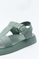 Sandalia baja negra con tiras anchas y hebilla lateral.