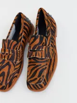 Mocasines de cuero con estampado animal print de tigre en tonos marrones y negros. Diseñados en Uruguay y producidos en Brasil.
