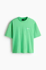 Remera de algodón color verde con cuello redondo acanalado, hombros caídos y bordado pequeño en el pecho con la palabra Golden.