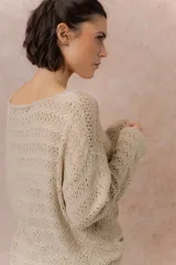 Sweater tejido calado color beige, con escote amplio y mangas largas de calce relajado.