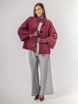 Chaqueta tipo capa de textura peluda en color bordó, con cuello mao y cierre frontal con botones grandes.