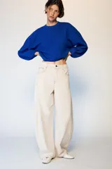 Jeans de tiro medio con diseño barrel, corte holgado que se estrecha hacia el tobillo y cinco bolsillos. Presenta costuras a contraste y cierre frontal con cremallera y botón.