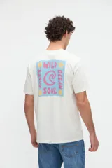 Remera de manga corta color blanco off-white, de calce clásico en tejido jersey de algodón. Presenta un gran diseño estampado en la espalda con un recuadro celeste que incluye las leyendas "WILD OCEAN" y "SALTY SOUL" junto con gráficos de olas y estrellas en tonos rosados y amarillos.