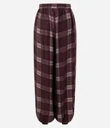 Pantalón estilo balloon de corte amplio y holgado, confeccionado en tejido de viscosa con estampado de cuadros en tonos bordó y blanco. Presenta cintura lisa y fruncido en los tobillos para un mayor volumen.