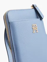 Cartera para móvil Tommy Hilfiger color celeste con correa ajustable, cierre de cremallera, múltiples ranuras para tarjetas, bolsillo interior con cremallera y bolsillo exterior para móvil.