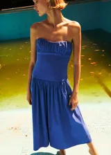Vestido midi azul sin tirantes, con escote palabra de honor fruncido en el pecho, corte ajustado en el torso y falda amplia de corte evasé.