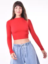 Remera crop de manga larga y cuello redondo, confeccionada en tejido de punto acanalado de color rojo.