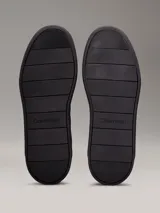 Zapatillas urbanas Calvin Klein de color negro, con detalles en cuero y gamuza. Presentan el logo de la marca en el lateral y suela de goma.
