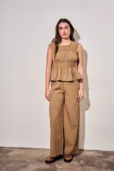 Blusa sin mangas de viscosa con estampado a cuadros vichy en tonos marrones y tostados, con doble fruncido elástico en el pecho y la cintura que genera un sutil vuelo inferior.
