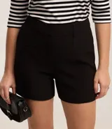 Bermuda femenina de sastrería color rojo, confeccionada en tejido de crepé. Presenta trabillas en la cintura, cierre delantero y bolsillos falsos.