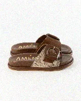 Sandalias de cuero color negro, de diseño plano con una tira ancha en el empeine y una hebilla metálica dorada grande como detalle.