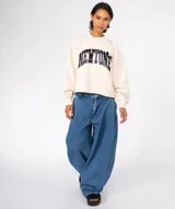 Buzo de algodón color verde oliva con lavado especial, cuello redondo y mangas largas con puños ajustados. Presenta un estampado frontal con la palabra "NEWTONE" en letras negras con efecto puff, y apliques decorativos redondos en el pecho. El ruedo inferior es cortado y deshilachado.