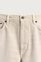 Jeans baggy fit confeccionados en denim de algodón color beige, de corte holgado y amplio en toda la pierna, con tiro medio y diseño de cinco bolsillos.