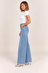 Jeans de denim celestes de tiro alto, corte wide leg y terminación desmechada en el bajo.