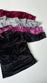 Buzo negro de terciopelo con escote en V y bolsillos frontales.