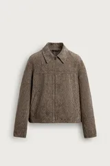 Cazadora relaxed fit de hombre, confeccionada en tejido jacquard texturizado color marrón con patrón geométrico en zigzag. Cuenta con cuello solapa, manga larga, bolsillos de vivo en la cadera y cierre frontal con cremallera.
