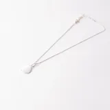 Tobillera plateada con cadena de eslabones y dije circular.