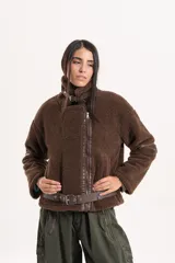 Chaqueta tipo gamulán de textura de corderito en color marrón, con cierre frontal, solapas amplias y detalles de correas ajustables en la cintura y mangas.