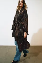 Chaqueta larga tipo kimono de Zara, confeccionada en mezcla de lino y seda con diseño jacquard estampado en tonos marrones y oscuros, manga larga y cinturón ajustable del mismo tejido.