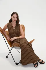 Vestido midi de poliéster color marrón con rayas verticales negras, sin mangas, escote en V con abertura tipo gota y detalle de argolla.