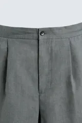 Pantalón de corte straight relaxed fit confeccionado en tejido de lino. Presenta cintura con pliegues frontales, cierre frontal con cremallera y botón, bolsillos laterales y bolsillos traseros con solapa.