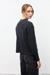 Sweater de punto color gris grafito, con cuello redondo, manga larga y puños y ruedo acanalados.