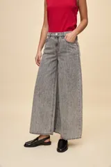 Jean wide leg de tiro alto color celeste, con calce amplio y pierna ancha, diseño de cinco bolsillos y cierre frontal con botón y cremallera.