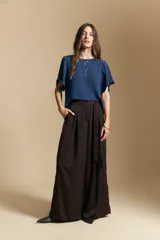 Top de color azul, con escote redondo a la base y mangas cortas amplias con caída fluida. Presenta una silueta relajada y un diseño minimalista.