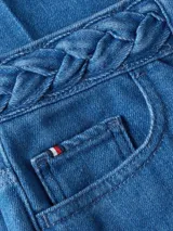 Pantalón de jean azul de pierna ancha y talle alto, con detalle de cintura trenzada, cierre de botón y cremallera, diseño de cinco bolsillos y logo de Tommy Hilfiger bordado en los bolsillos delantero y trasero.